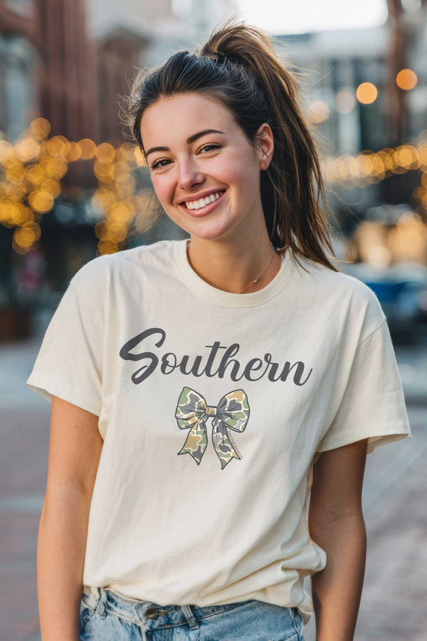 Woman wearing a 'Southern' t-shirt with a bow graphic on a city street.