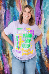 Woman wearing a colorful graphic t-shirt against a vibrant, abstract wall.