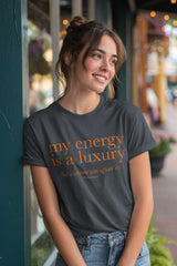 Woman wearing a t-shirt with 'my energy is a luxury' text on a street background